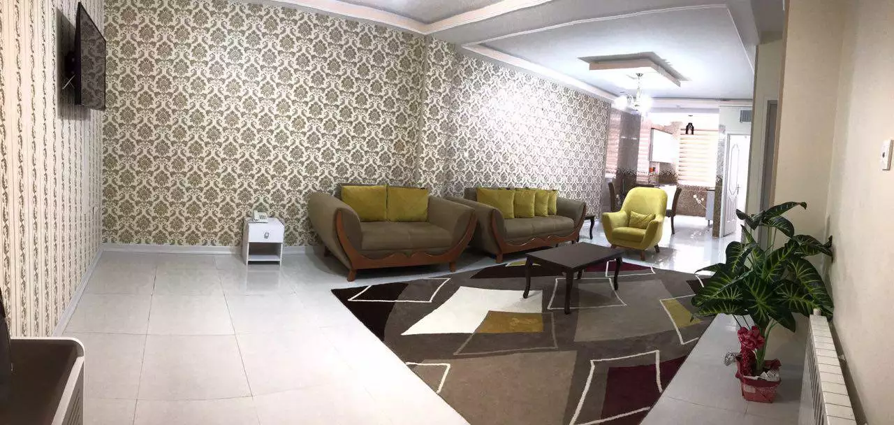 سالن نشیمن هتل سینا با مبلهای سبز و فرش هندسی