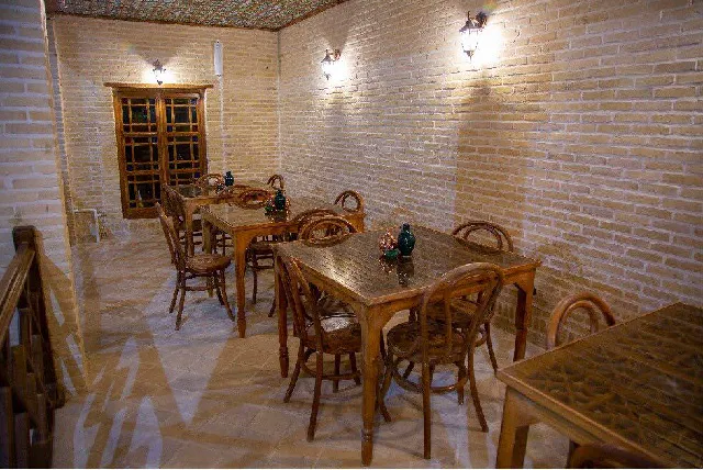 فضای غذاخوری هتل ددمان با میز و صندلی چوبی
