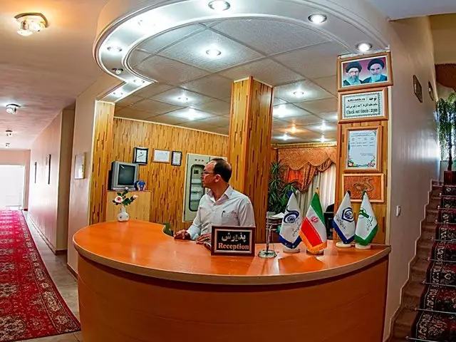 پیشخوان پذیرش هتل جهانگردی با کارمند و پرچمها