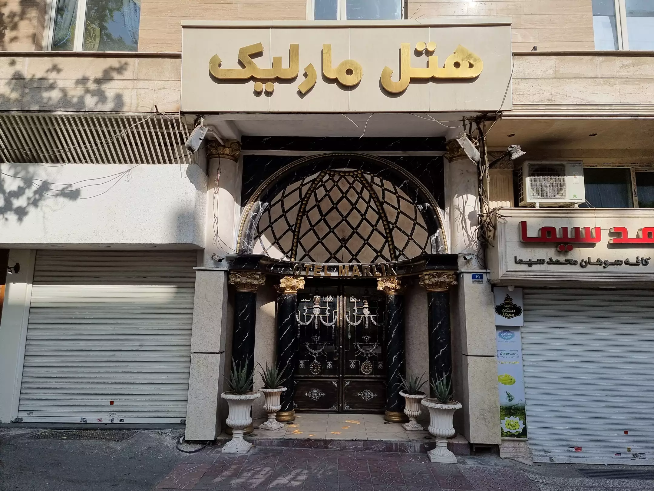 ورودی هتل مارلیک با سردر و در فلزی مشبک
