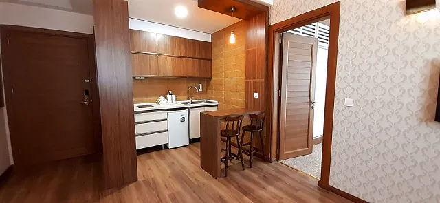 آشپزخانه سوئیت هتل کتیبه با کابینت چوبی و میز صبحانه
