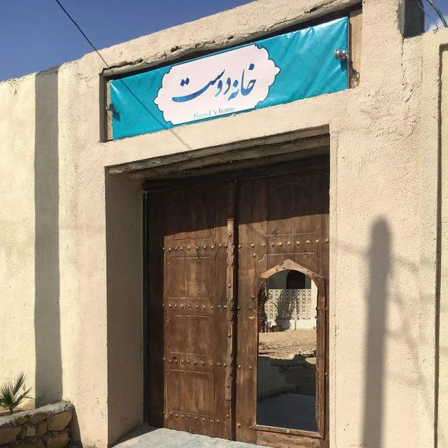 ورودی چوبی خانه دوست با تابلوی فیروزه‌ای