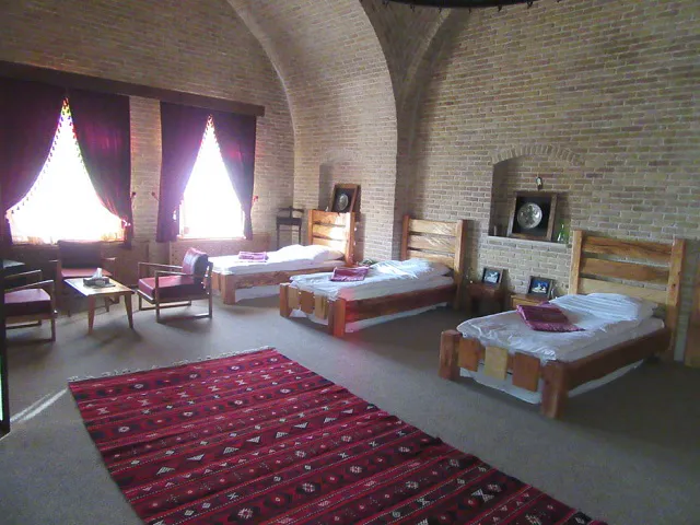 اتاق کاروانسرای یام با سه تخت و فرش قرمز