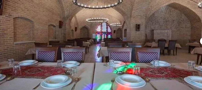 سالن غذاخوری کاروانسرای یام با میزهای چیدهشده