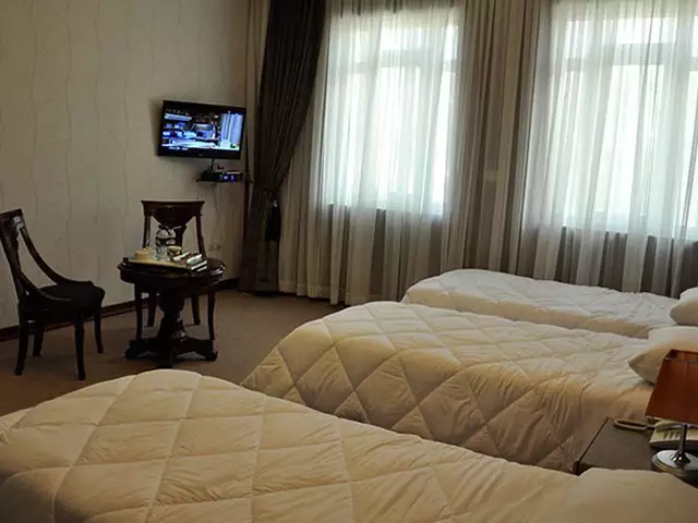 اتاق جهانگردی با دو تخت و پنجره پرده‌دار
