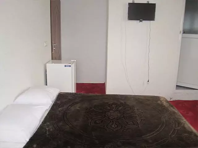 تخت دونفره و تلویزیون در اتاق هتل نگین استیل