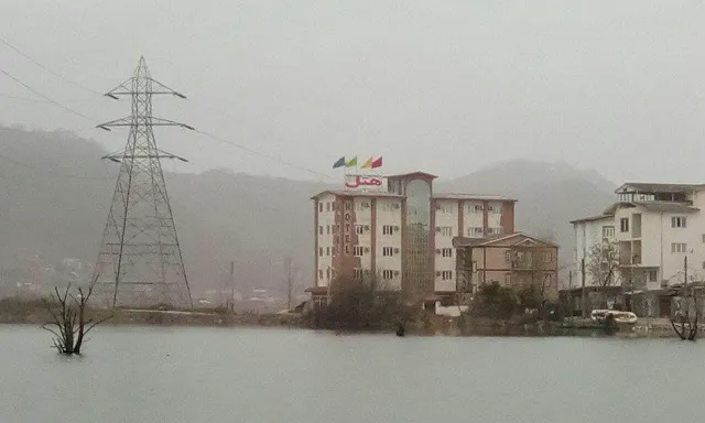 هتل نگین استیل در کنار آب و کوهستان مه‌آلود