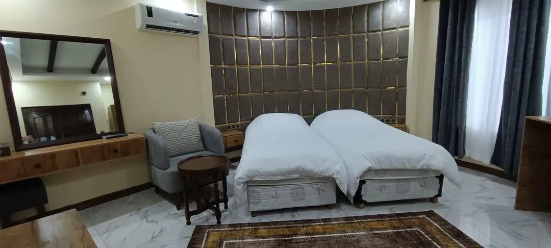 دو تخت یکنفره کنار دیوار طلایی هتل پاپیون