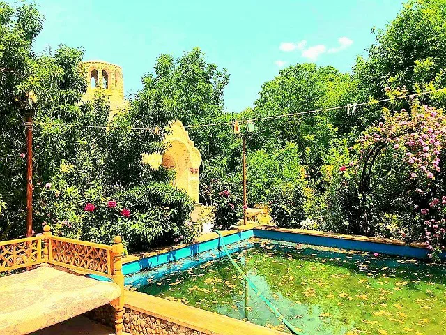 حوض آب در میان باغ سرسبز سرای جهانگرد