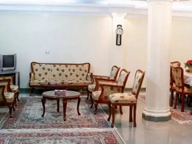 نشیمن مبله هتل صدرا با فرش و میز چوبی