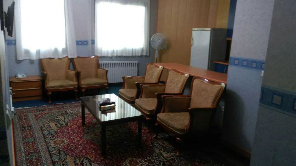 فضای نشیمن با صندلی‌های چرمی و فرش در هتل صدرا