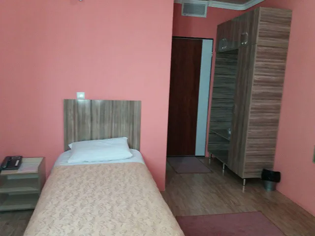 تخت یک‌نفره و کمد چوبی اتاق هتل آتا