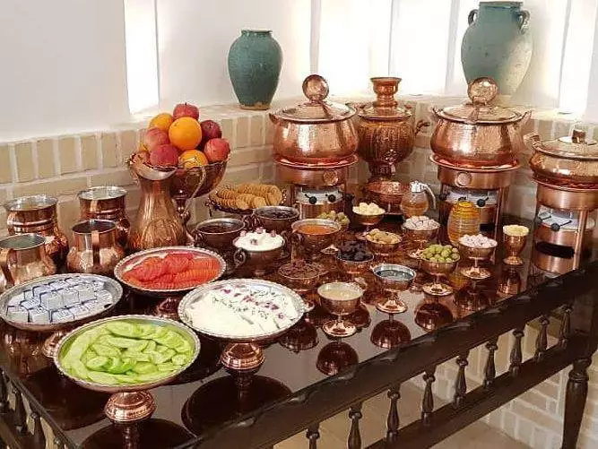 میز صبحانه هتل اطلسی با ظروف مسی و خوراکی‌ها