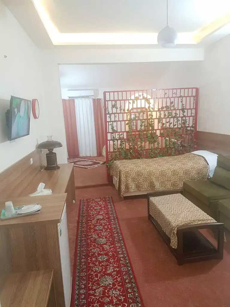 اتاق هتل اسرم با تخت و جداکننده چوبی
