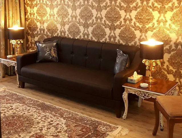 مبل چرمی تیره و فرش طرحدار در هتل بغدادی