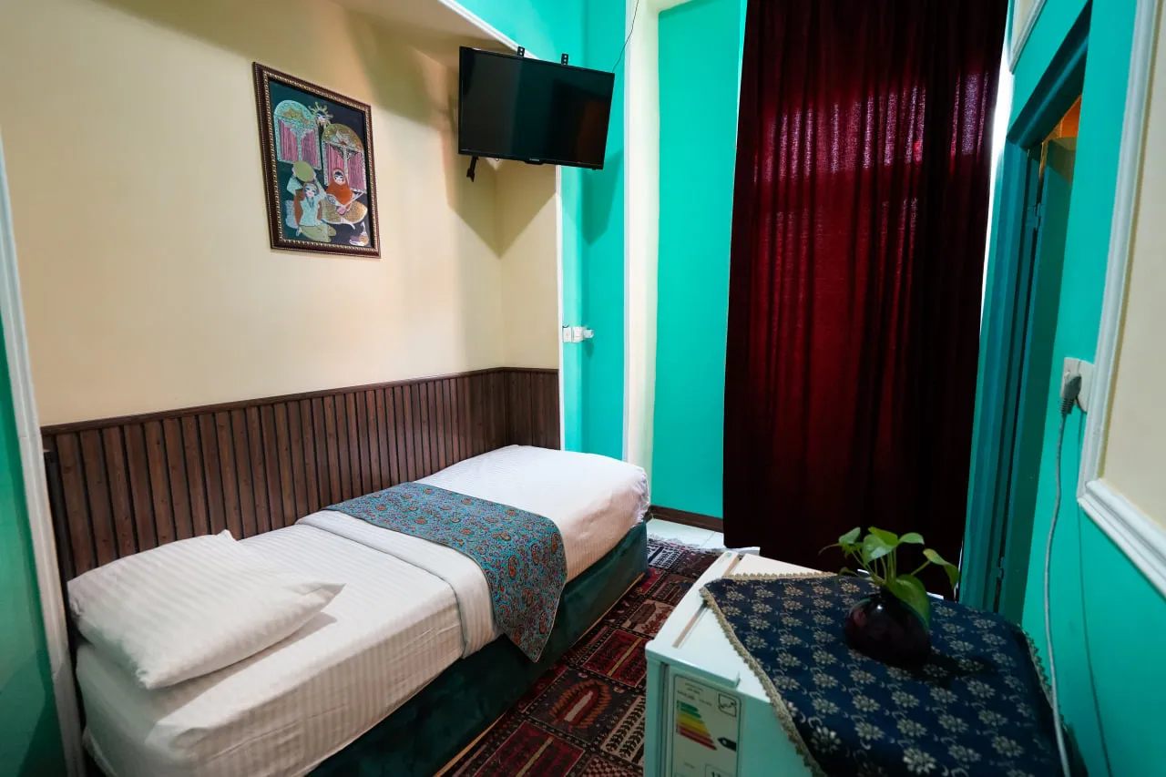 اتاق یک‌نفره سرای هاتف با دیوارهای فیروزه‌ای