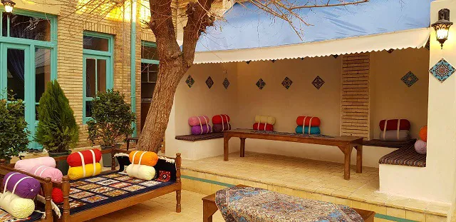 حیاط سرای هاتف با تخت سنتی و نشیمن دیواری