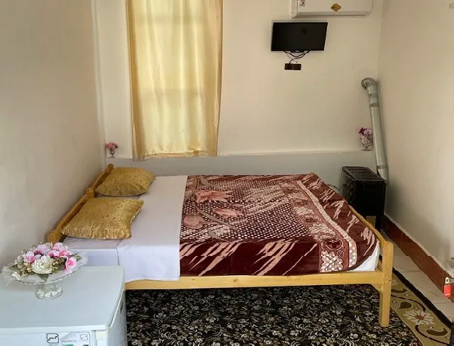 تخت دونفره با روتختی طرح‌دار در باغ سرهنگ