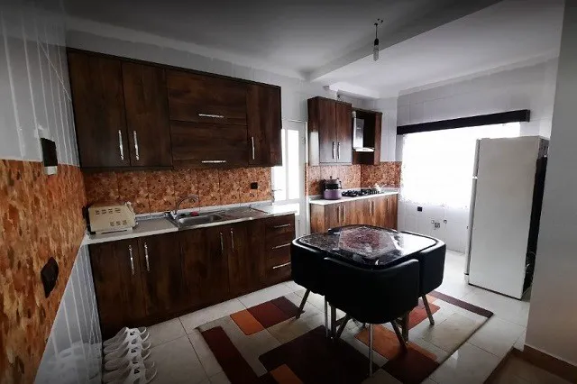 آشپزخانه باغ سرهنگ با کابینت چوبی و میز غذاخوری