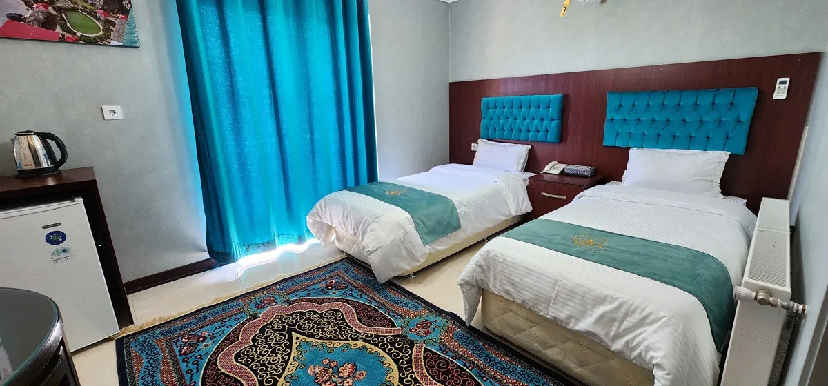 اتاق دوتخته هتل نور با تاج تخت فیروزه‌ای