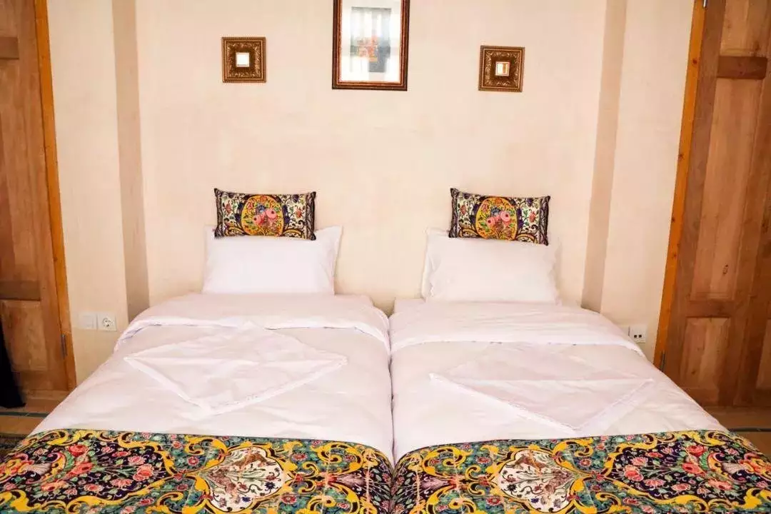 دو تخت یک‌نفره کاشانه روشن با روتختی ترمه