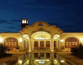 نمای شبانه عمارت یاسمین راهب با حوض انعکاس‌دار