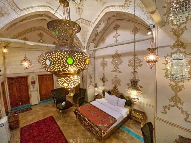 اتاق خواب خانه کشیش با تخت و چراغهای آویز سنتی