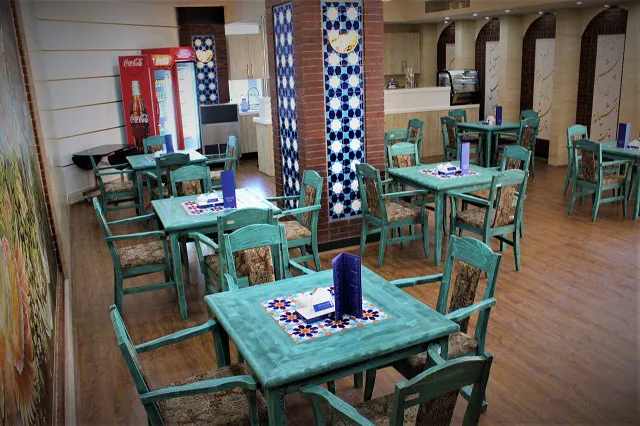 چیدمان میزهای فیروزهای در رستوران هتل مرآت