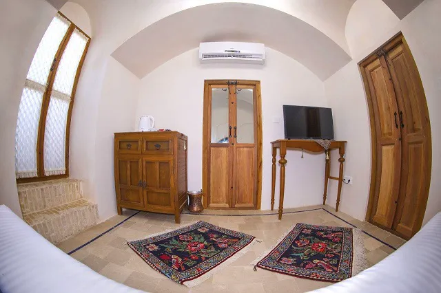 فضای نشیمن هتل کاسیان با تلویزیون و قالی