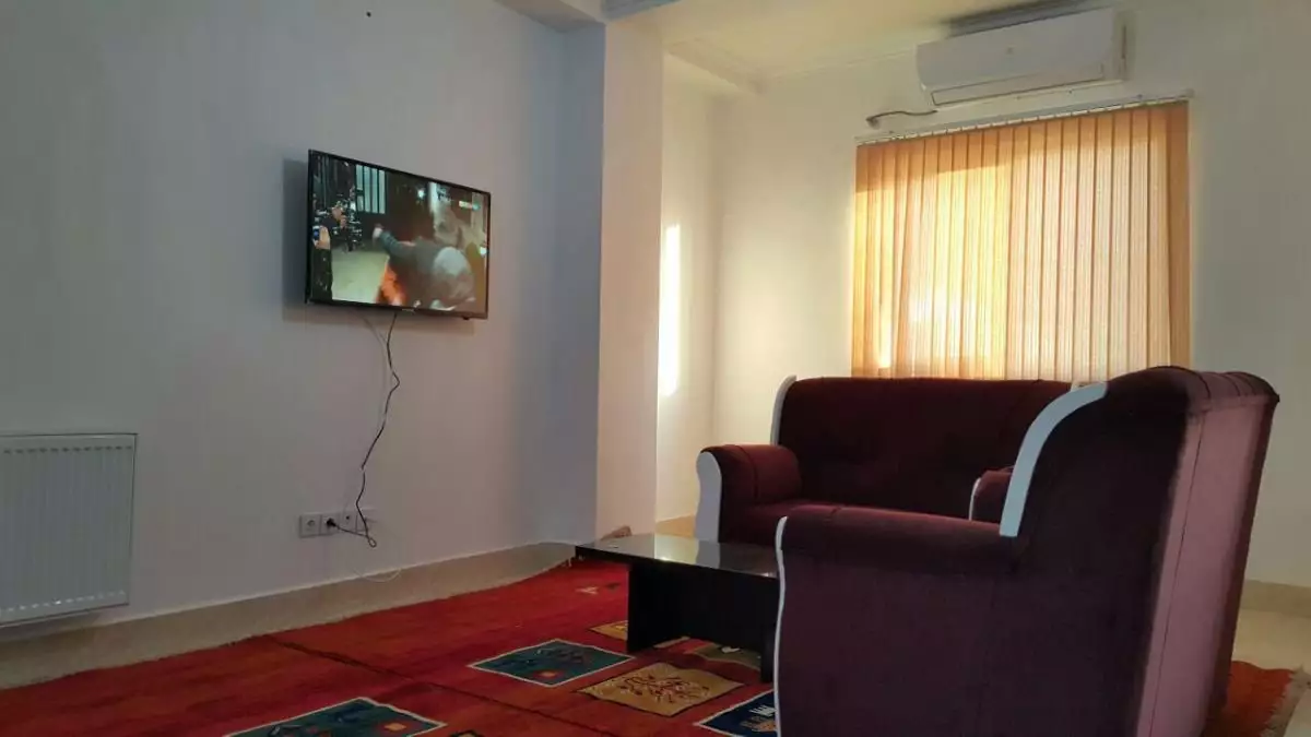 نشیمن اتاق هتل اطلس با مبل و تلویزیون