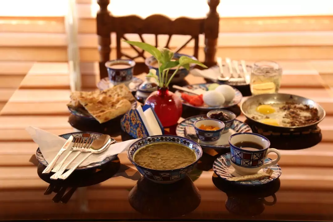 چیدمان صبحانه شامل نان، تخم‌مرغ و چای در هتل انار