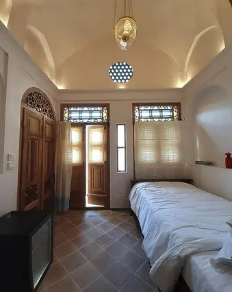 اتاق سوریجان با تخت یک‌نفره و در چوبی