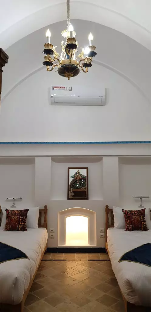 اتاق اقامتگاه گیواک با دو تخت یک‌نفره و لوستر