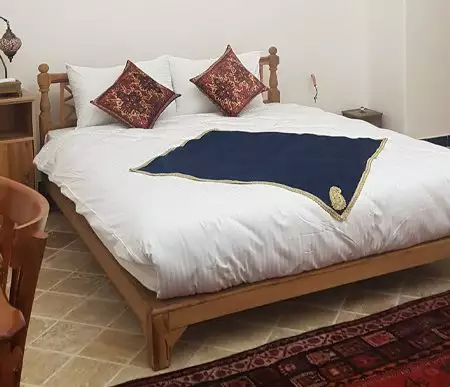 تخت دونفره چوبی اقامتگاه گیواک با روتختی سفید