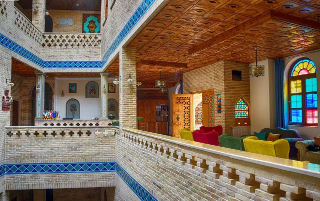 نشیمن سنتی درباری با پنجره‌های رنگی و مبل‌ها