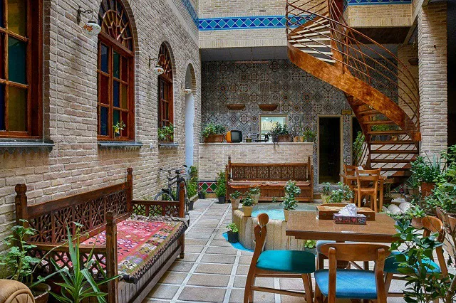 حیاط سنتی درباری با تخت و میزهای چوبی