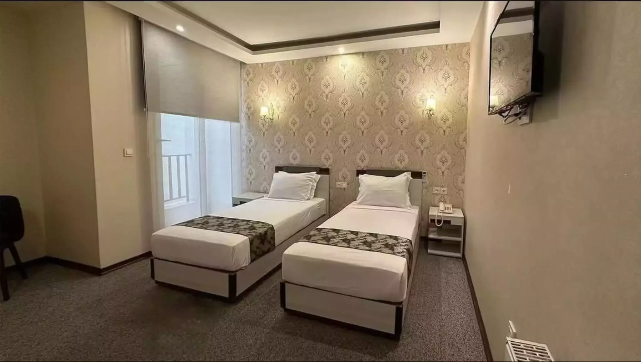 دو تخت یک‌نفره در اتاق هتل ورنوس