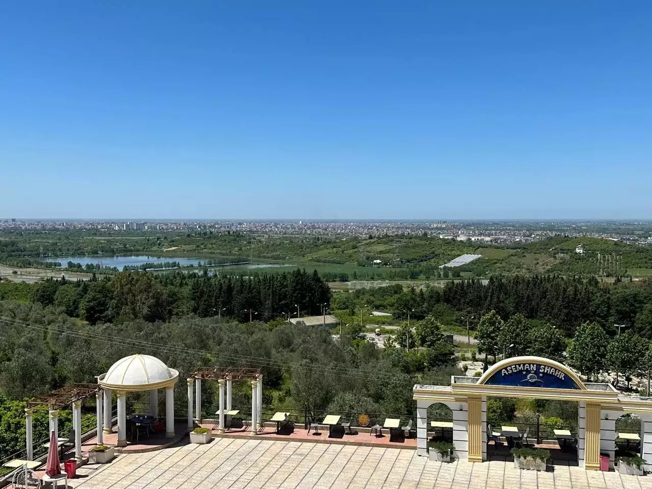 محوطه سنگ‌فرش هتل آسمان شهر با چشم‌انداز جنگل
