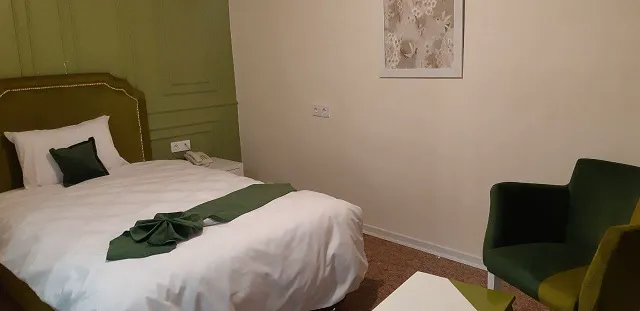 اتاق هتل زاگرس با تخت و صندلی سبز