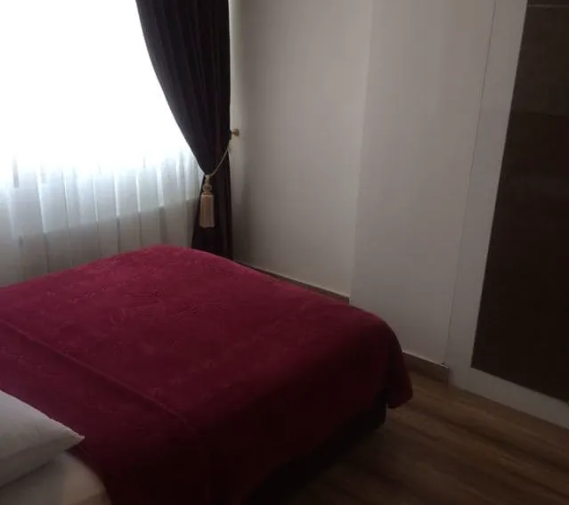 تخت با روتختی زرشکی کنار پنجره هتل گیلبرتون