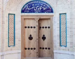 در چوبی ورودی اقامتگاه شهباز با کوبههای فلزی