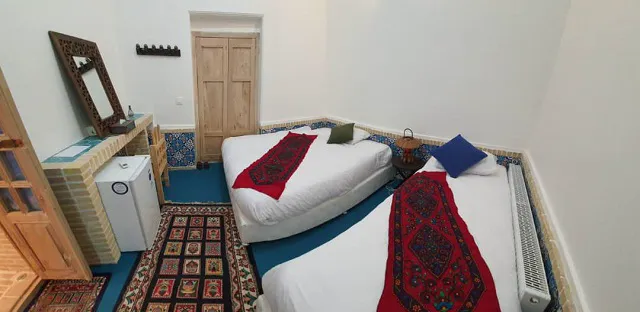 دو تخت و فرش سنتی در اتاق هتل شهباز