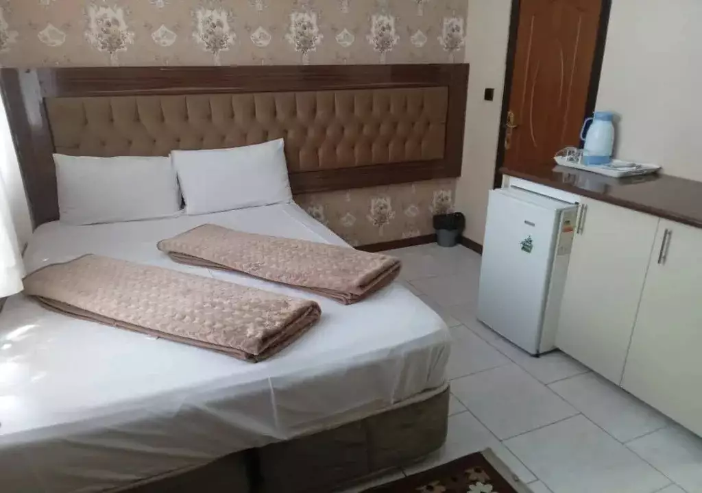 تخت دونفره و یخچال اتاق هتل هرمس