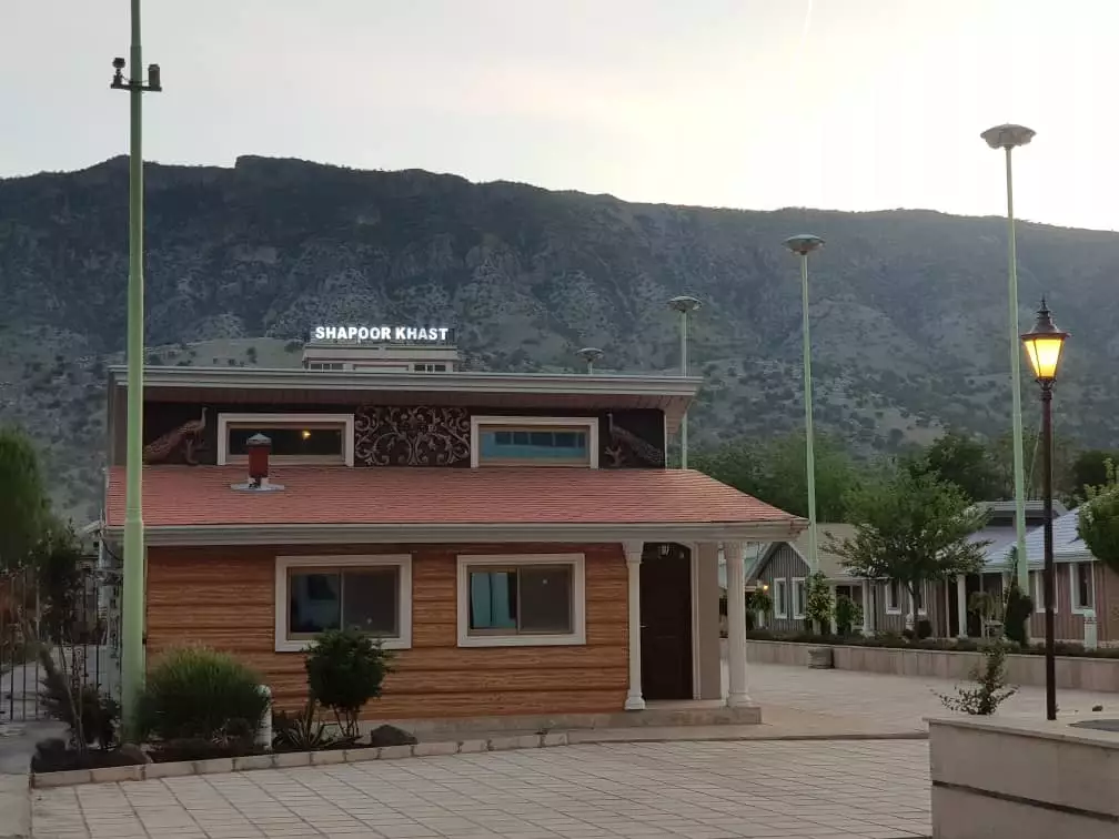 ساختمان چوبی هتل شاپورخواست در پسزمینه کوهستان