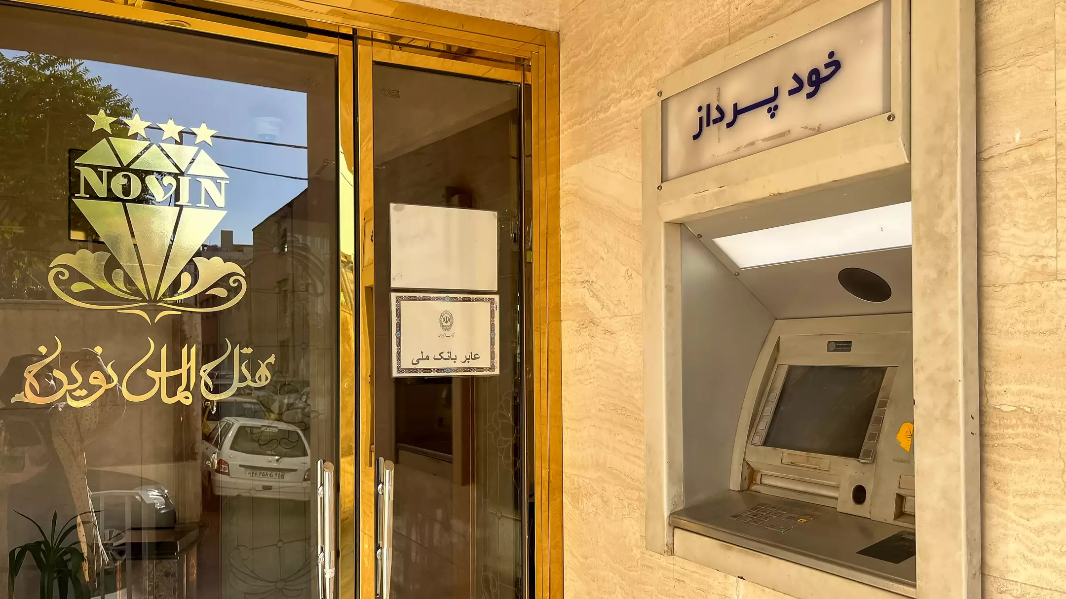 دستگاه خودپرداز کنار ورودی شیشه‌ای هتل نوین