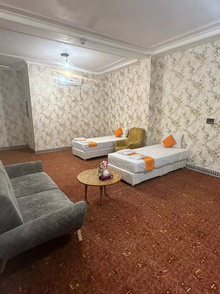 دو تخت یک‌نفره و مبل در اتاق شوهاز