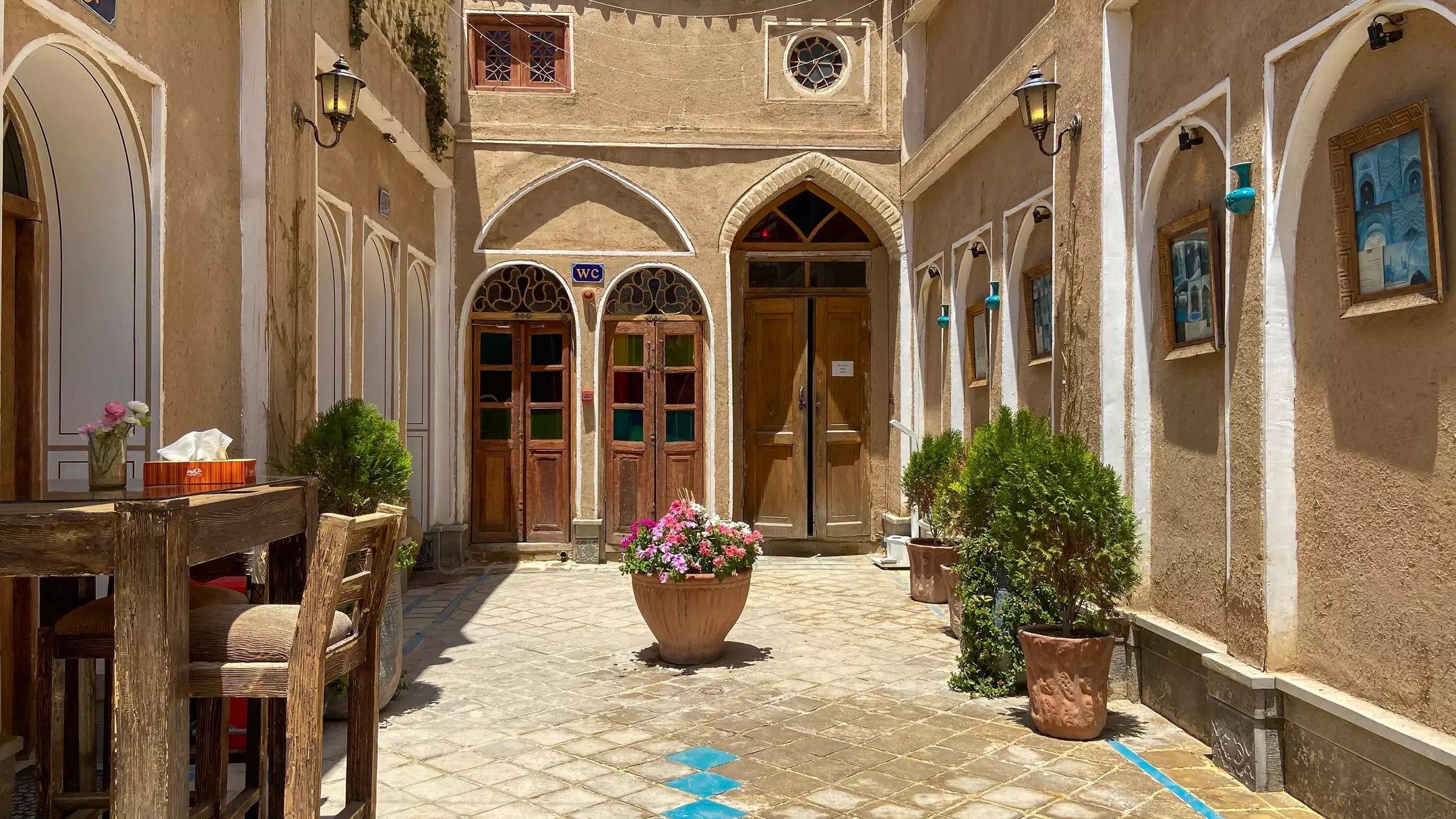 حیاط سنتی هتل یاس با گلدان‌های گل