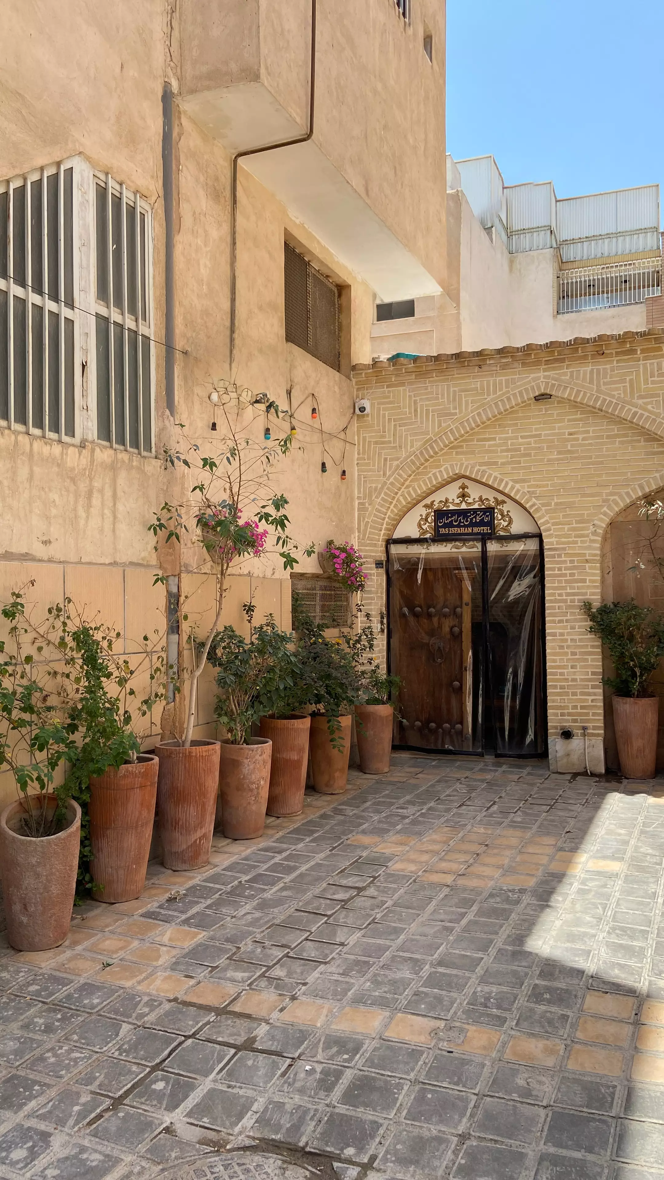 ورودی آجری هتل یاس در حیاط سنگفرششده