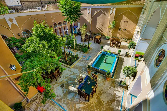 حیاط هتل یاس با حوض و میزهای فضای باز