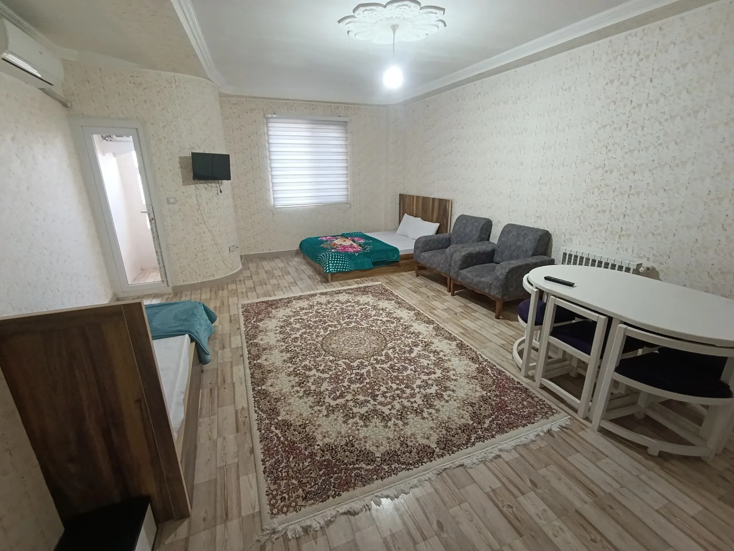 اتاق نشیمن هتل آهوان با مبل، فرش و میز غذاخوری